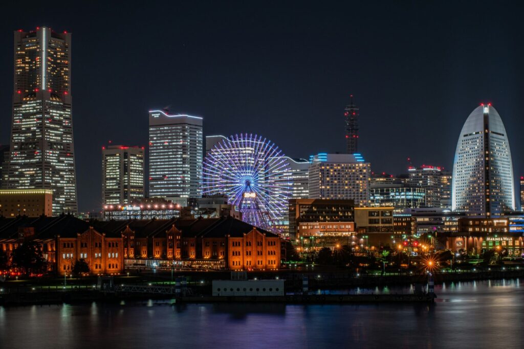 The image shows the bright night skyline of the Minato Mirai 21 waterfront district in Yokohama, Japan, for Spectrum of the Seas Sailing the Eastern Odyssey.
